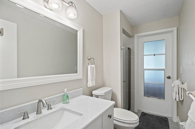 bathroom with an enclosed shower, tile flooring, vanity, and toilet