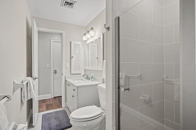 bathroom with an enclosed shower, wood-type flooring, vanity, and toilet