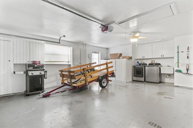 garage with ceiling fan, sink, a garage door opener, and independent washer and dryer