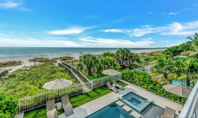 birds eye view of property featuring a water view and a beach view