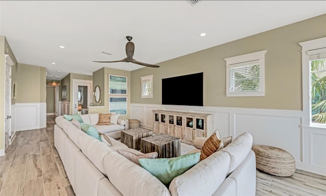 living room featuring light hardwood / wood-style flooring, a wealth of natural light, and ceiling fan