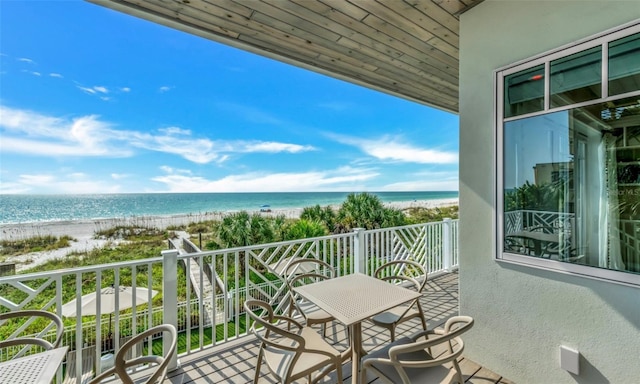 balcony with a water view and a view of the beach