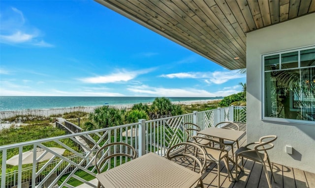 balcony featuring a beach view and a water view