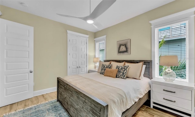 bedroom featuring multiple windows, ceiling fan, and light hardwood / wood-style flooring