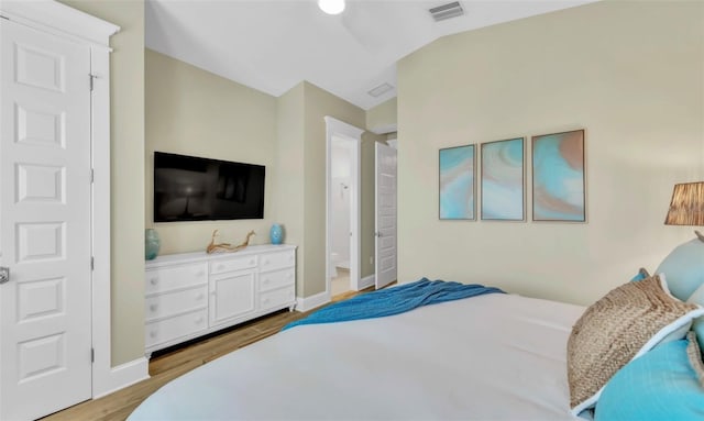 bedroom with light hardwood / wood-style flooring and lofted ceiling