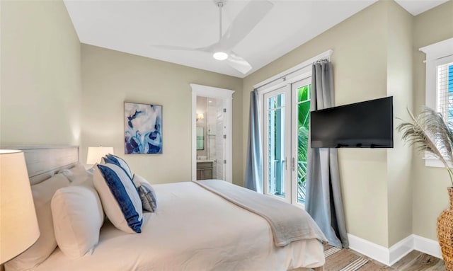 bedroom featuring ceiling fan, light hardwood / wood-style floors, multiple windows, and ensuite bath