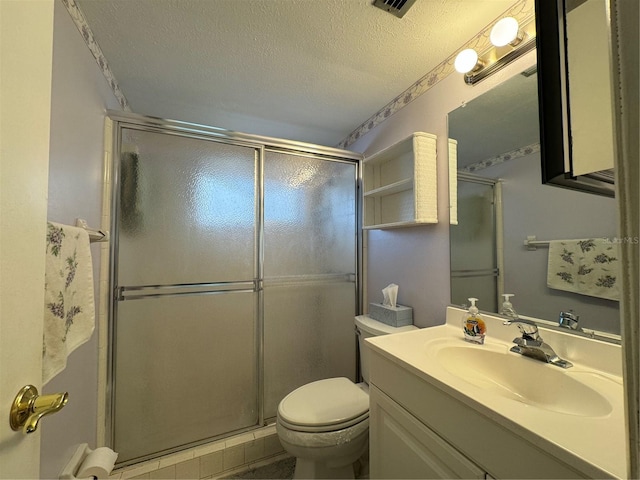 bathroom with vanity, toilet, a shower with door, and a textured ceiling