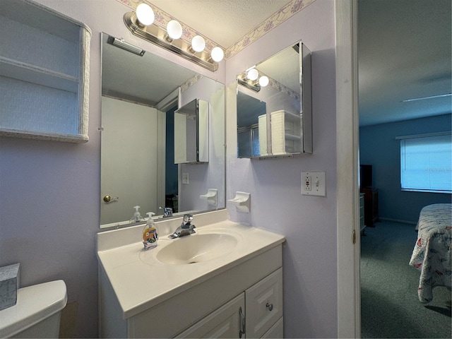 bathroom with vanity, a textured ceiling, and toilet