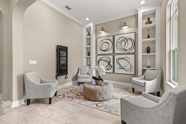 living area with built in shelves, plenty of natural light, and crown molding