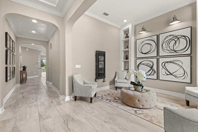 living area with built in shelves and ornamental molding