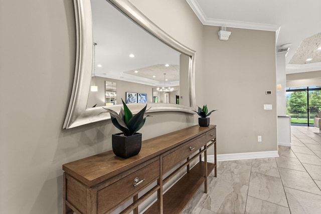 hallway featuring a notable chandelier, a raised ceiling, and crown molding