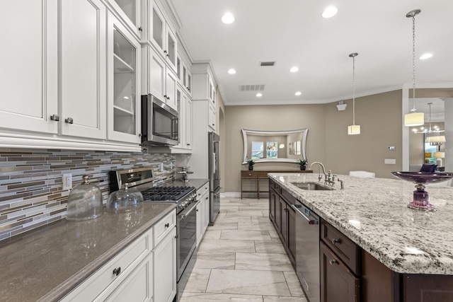 kitchen with dark brown cabinetry, sink, premium appliances, tasteful backsplash, and white cabinets