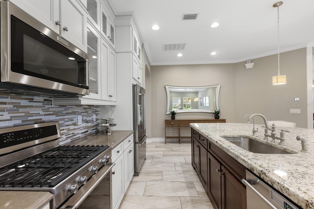 kitchen with white cabinets, sink, stainless steel appliances, and hanging light fixtures