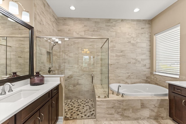 bathroom featuring vanity, tile walls, and independent shower and bath