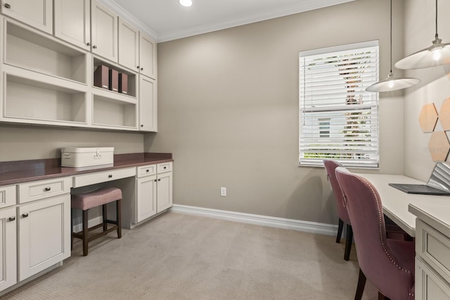 home office featuring light carpet, crown molding, and built in desk