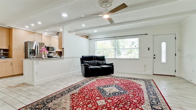 living area with ceiling fan, light wood finished floors, beam ceiling, and baseboards