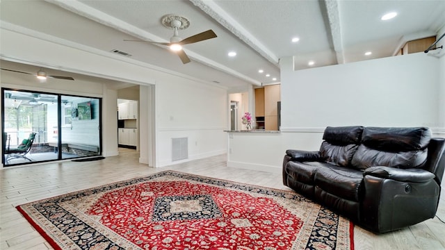 living room with ceiling fan, beam ceiling, and light wood-type flooring