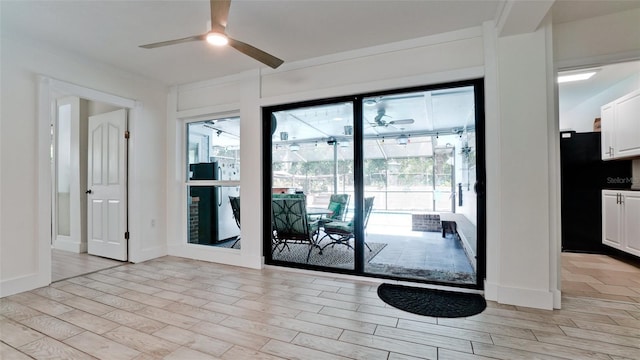 entryway featuring ceiling fan, light wood-style flooring, and a healthy amount of sunlight