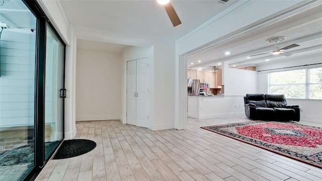 interior space with ceiling fan and light wood finished floors