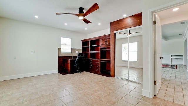 office area featuring baseboards, a ceiling fan, and a healthy amount of sunlight