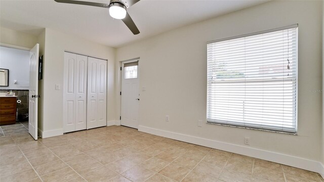 unfurnished bedroom with a closet, ceiling fan, and light tile patterned flooring