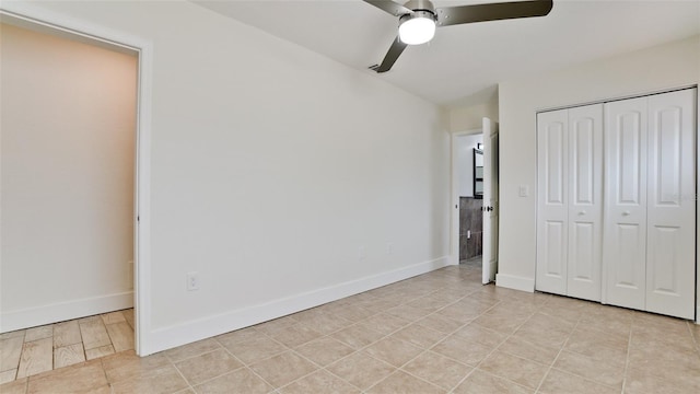 unfurnished bedroom with a ceiling fan, light tile patterned floors, baseboards, and a closet