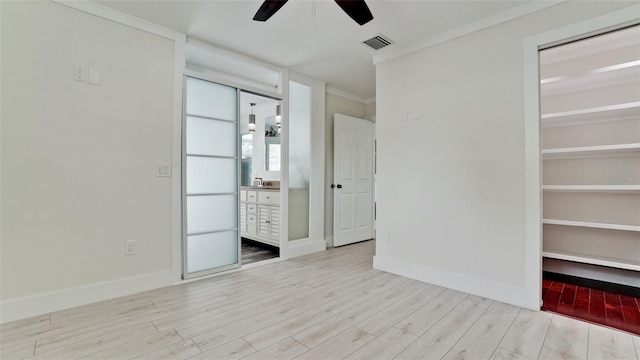 unfurnished bedroom with crown molding, baseboards, visible vents, and light wood-style floors