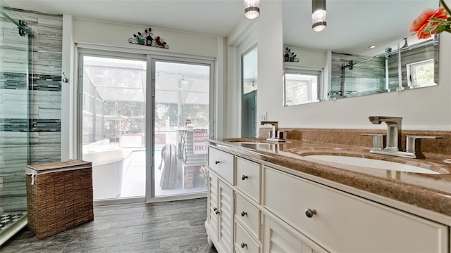 bathroom with hardwood / wood-style flooring, vanity, and a shower with door