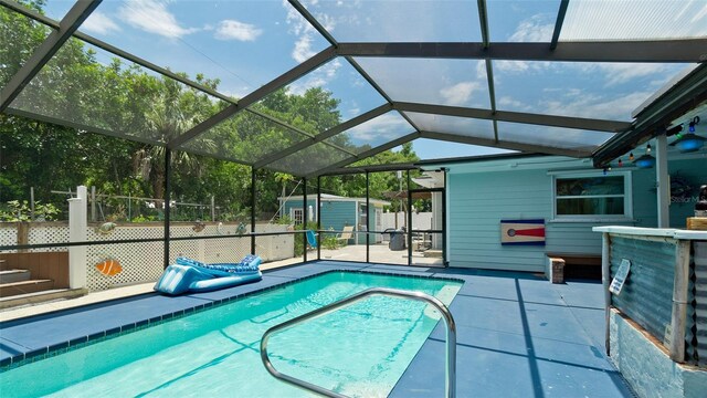 view of pool featuring a patio, a storage unit, and a lanai