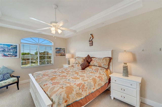 carpeted bedroom featuring ceiling fan and a tray ceiling