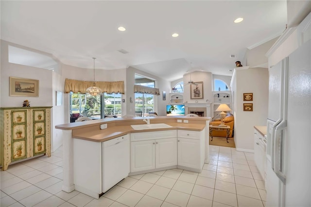 kitchen featuring white appliances, sink, light tile patterned floors, pendant lighting, and white cabinetry