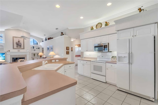 kitchen with white cabinets, light tile patterned floors, white appliances, and sink