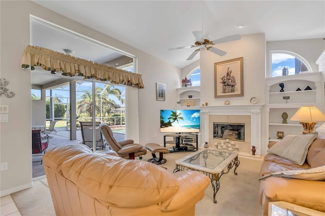 living room with ceiling fan, built in features, light tile patterned flooring, and lofted ceiling