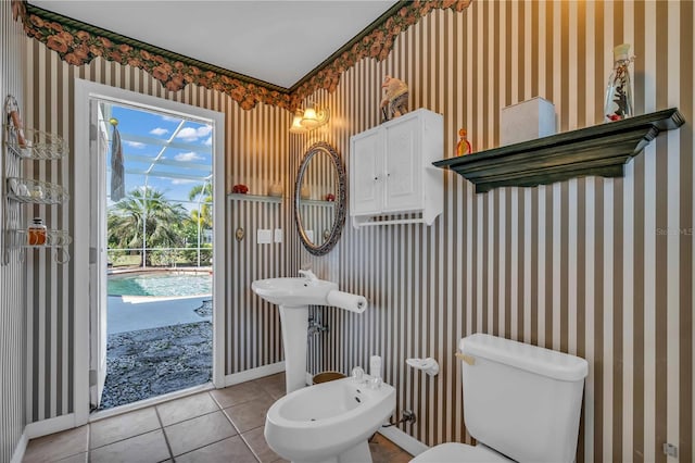 bathroom featuring toilet, tile patterned floors, and a bidet