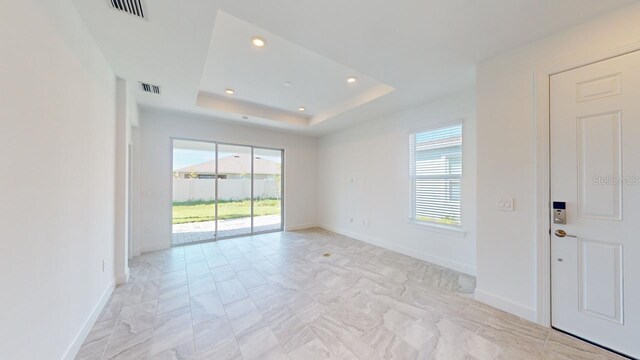 unfurnished room with a tray ceiling