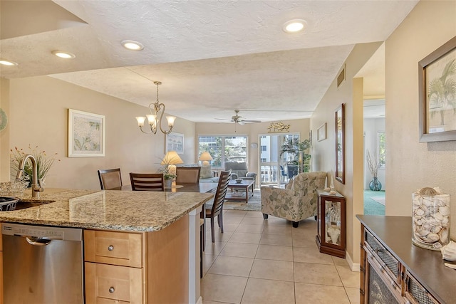 kitchen featuring visible vents, open floor plan, a sink, a textured ceiling, and dishwasher