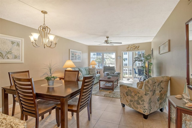 dining room with light tile patterned flooring and ceiling fan with notable chandelier