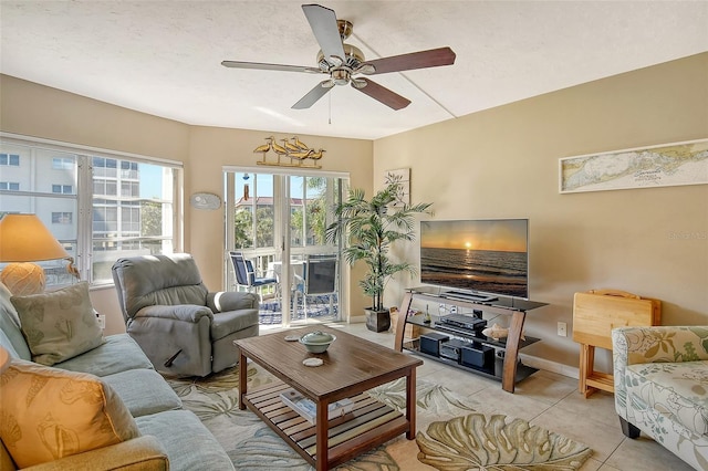 living room featuring baseboards, a ceiling fan, and light tile patterned flooring