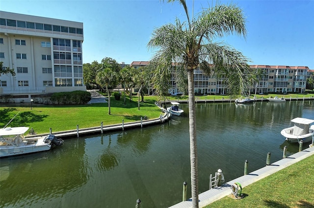 view of dock with a water view and a lawn