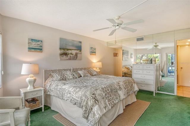 bedroom featuring a ceiling fan, a textured ceiling, visible vents, and carpet flooring