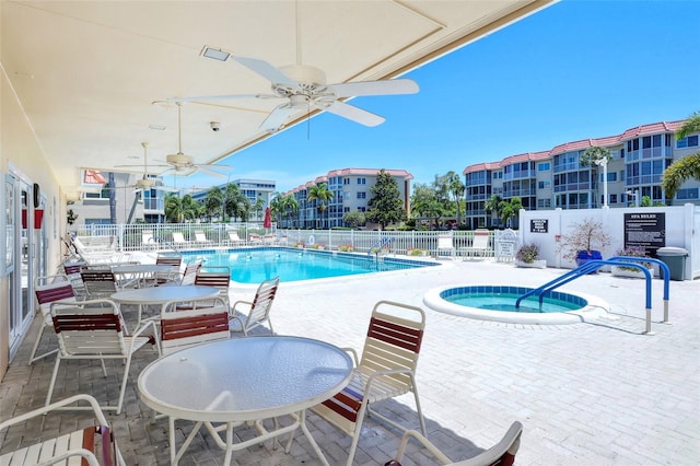 community pool featuring ceiling fan, a patio, fence, and a hot tub