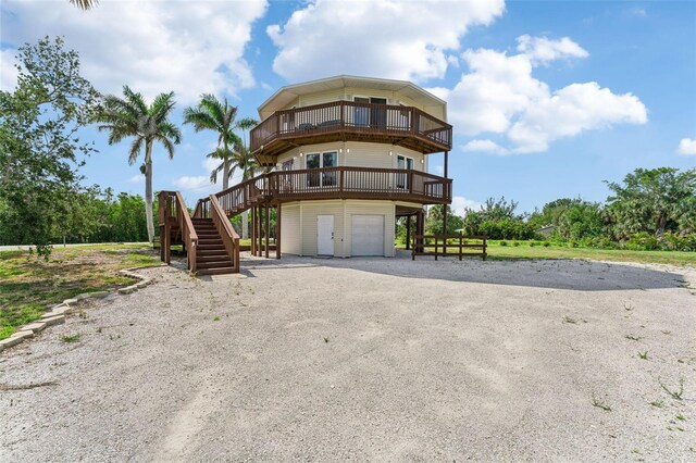 16361 Stringfellow Rd, Bokeelia, FL 33922 - view of building exterior with stairway, an attached garage, and driveway