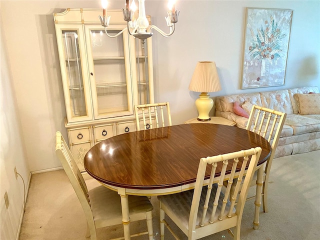 dining room featuring a notable chandelier and light carpet