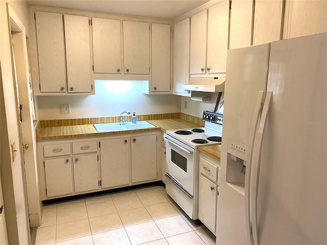 kitchen featuring light tile patterned flooring, white appliances, and sink