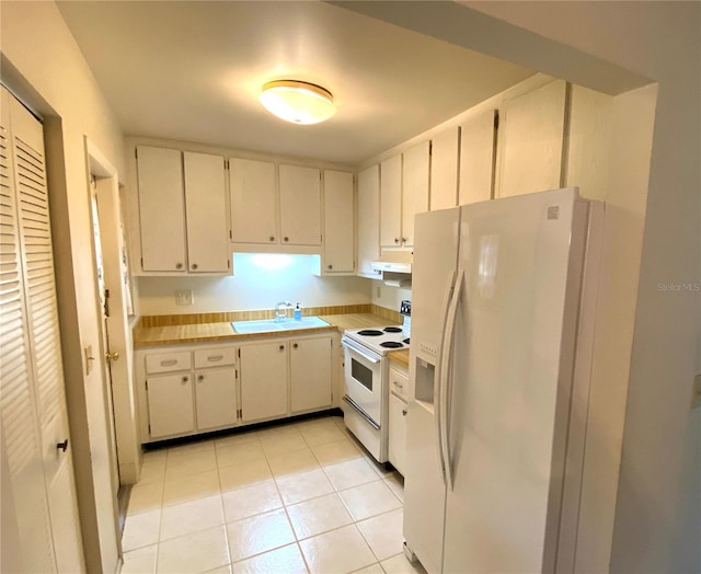 kitchen featuring sink, white appliances, and light tile patterned flooring