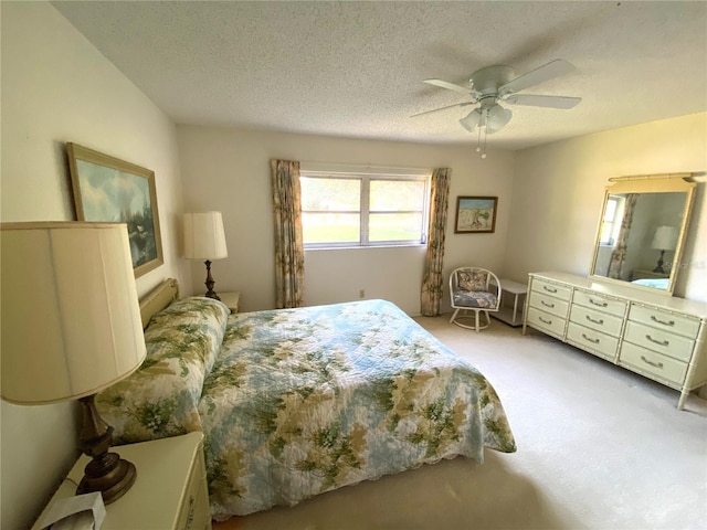 carpeted bedroom featuring ceiling fan and a textured ceiling