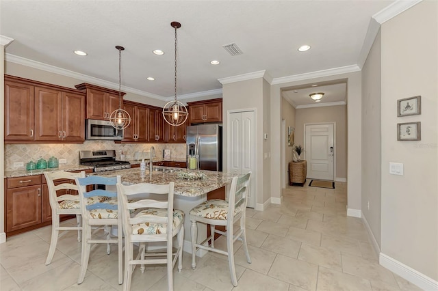 kitchen with light stone countertops, pendant lighting, stainless steel appliances, and a center island with sink