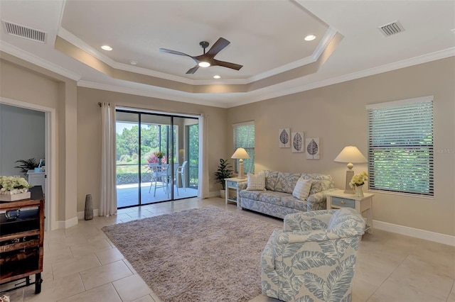 tiled living room featuring ceiling fan, crown molding, and a tray ceiling