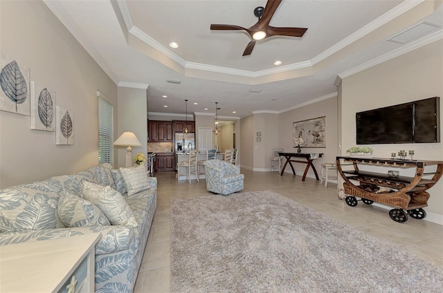 living room featuring light tile patterned floors, a raised ceiling, ceiling fan, and crown molding