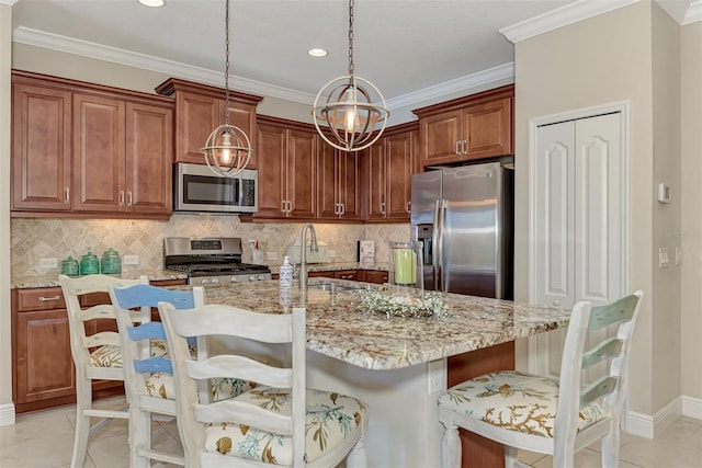 kitchen with pendant lighting, a kitchen island with sink, a breakfast bar area, light stone counters, and stainless steel appliances